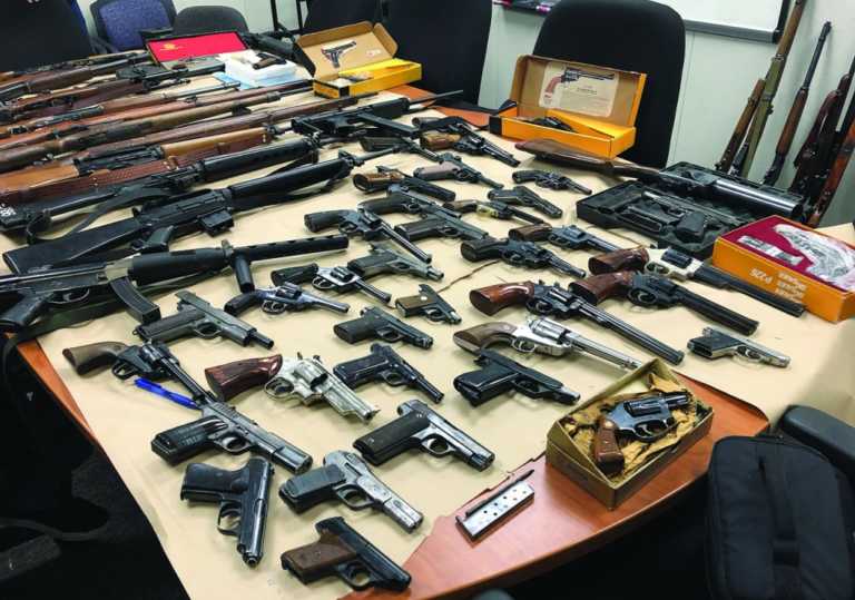 Two arrested with large cache of weapons