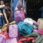 Image for display with article titled Volunteers Fill a Mountain of Backpacks During Stuff the Bus Event