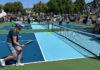 People playing pickleball outdoors on a freshly built court