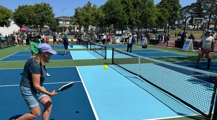 People playing pickleball outdoors on a freshly built court