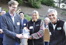 Group of people watching while an award is handed to a woman