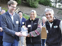 Group of people watching while an award is handed to a woman