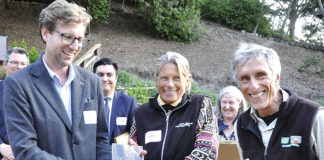 Group of people watching while an award is handed to a woman