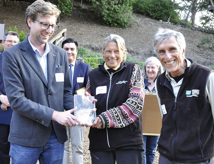 Farmers of the Year Group of people watching while an award is handed to a woman