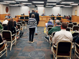 People waiting to talk at a government meeting