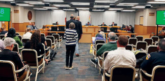 People waiting to talk at a government meeting