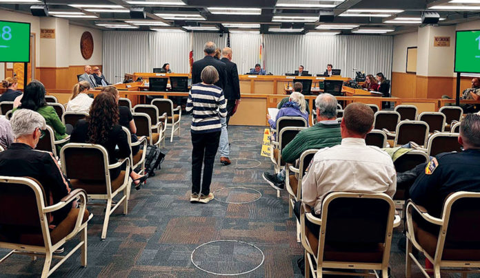 People waiting to talk at a government meeting