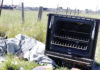 Broken stove tossed along the road in a scenic landscape