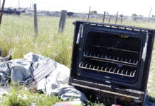 Broken stove tossed along the road in a scenic landscape