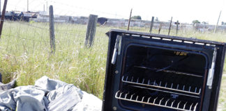 Broken stove tossed along the road in a scenic landscape