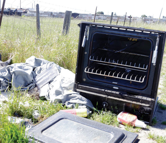 Broken stove tossed along the road in a scenic landscape