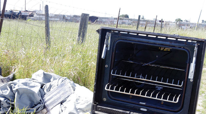 Broken stove tossed along the road in a scenic landscape