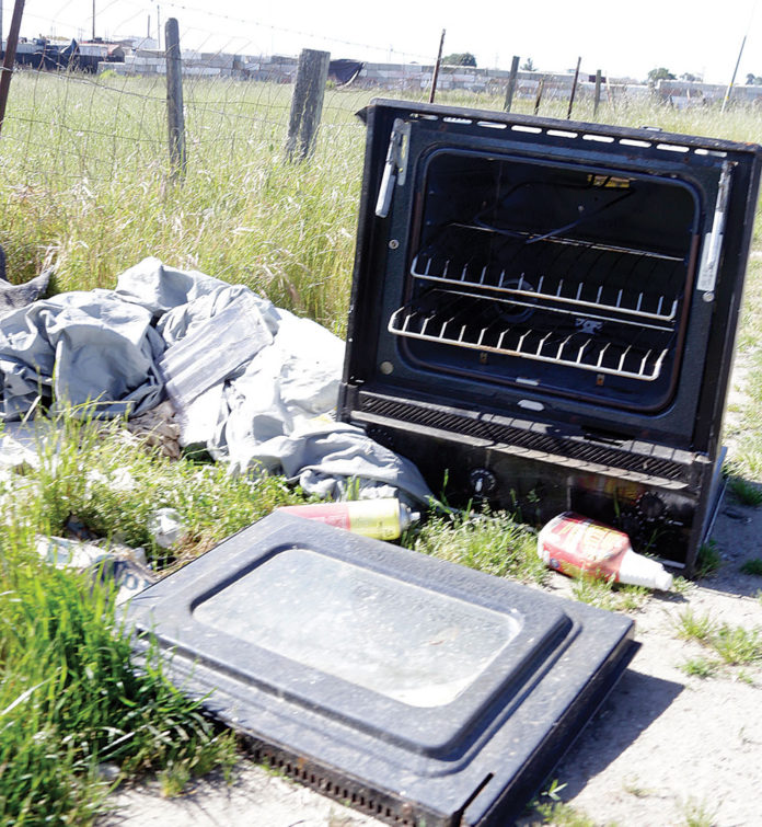 Broken stove tossed along the road in a scenic landscape
