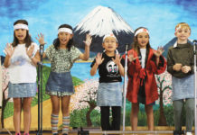 Five children performing on stage