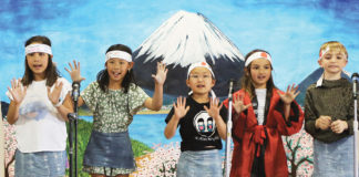 Five children performing on stage