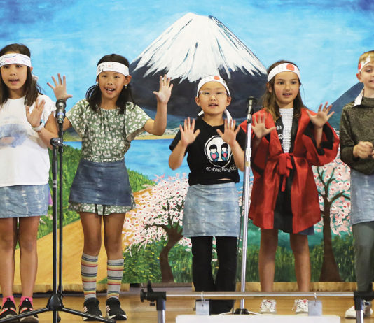 Five children performing on stage