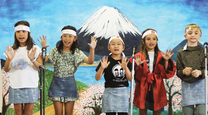 Five children performing on stage