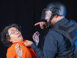 Two performers acting as prisoner and guard