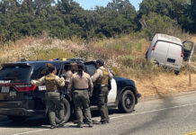 sheriffs look on at van that skidded off the road