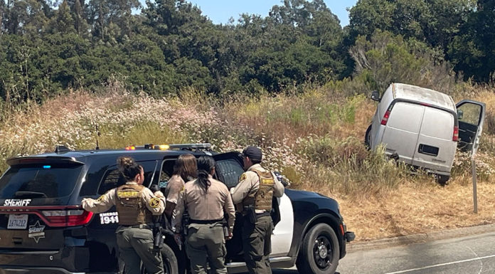 sheriffs look on at van that skidded off the road