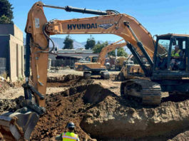 Work crews dig the foundation for a new apartment building on Main Street.
