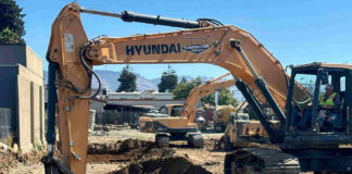 Work crews dig the foundation for a new apartment building on Main Street.