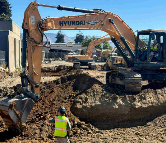 Work crews dig the foundation for a new apartment building on Main Street.