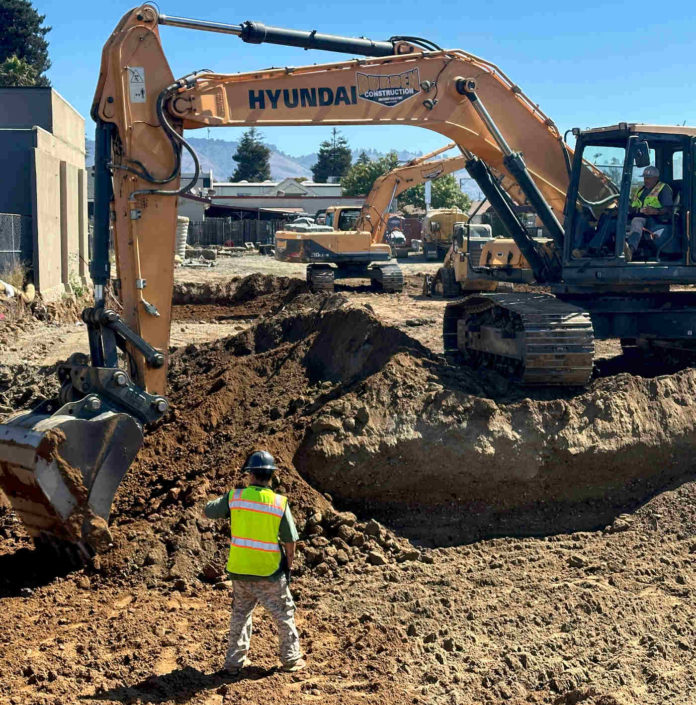 Hansen apt MAIN Work crews dig the foundation for a new apartment building on Main Street.