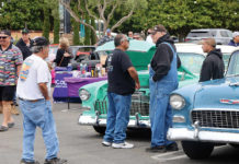 People check out a string of early-day cars and trucks Saturday in East Lake Village Shopping Center