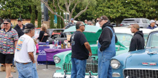 People check out a string of early-day cars and trucks Saturday in East Lake Village Shopping Center