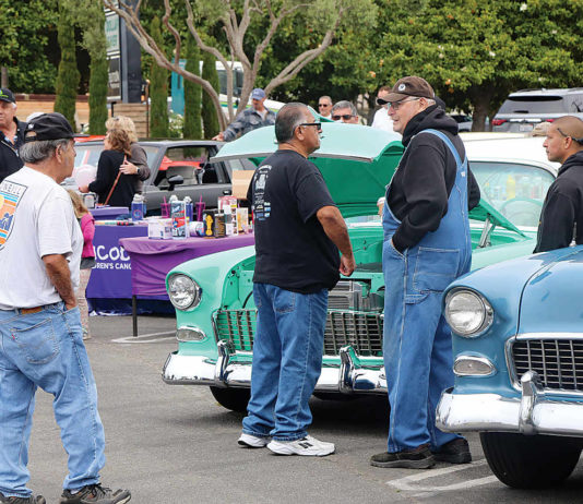 People check out a string of early-day cars and trucks Saturday in East Lake Village Shopping Center
