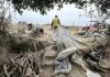 workers help clear makeshift shelters from the pajaro river levee