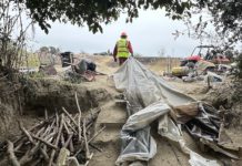 workers help clear makeshift shelters from the pajaro river levee