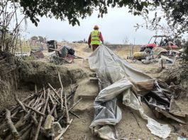 workers help clear makeshift shelters from the pajaro river levee