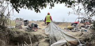 workers help clear makeshift shelters from the pajaro river levee