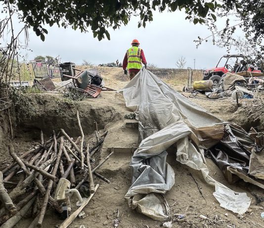 workers help clear makeshift shelters from the pajaro river levee