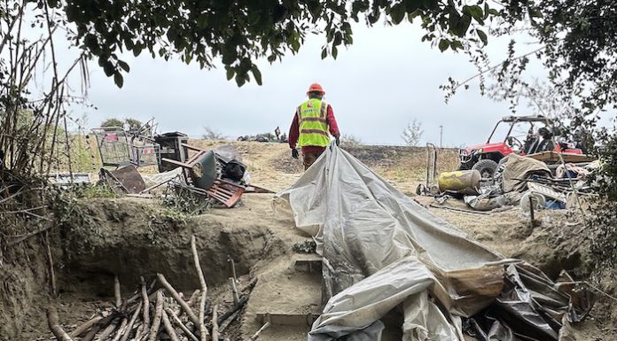 workers help clear makeshift shelters from the pajaro river levee