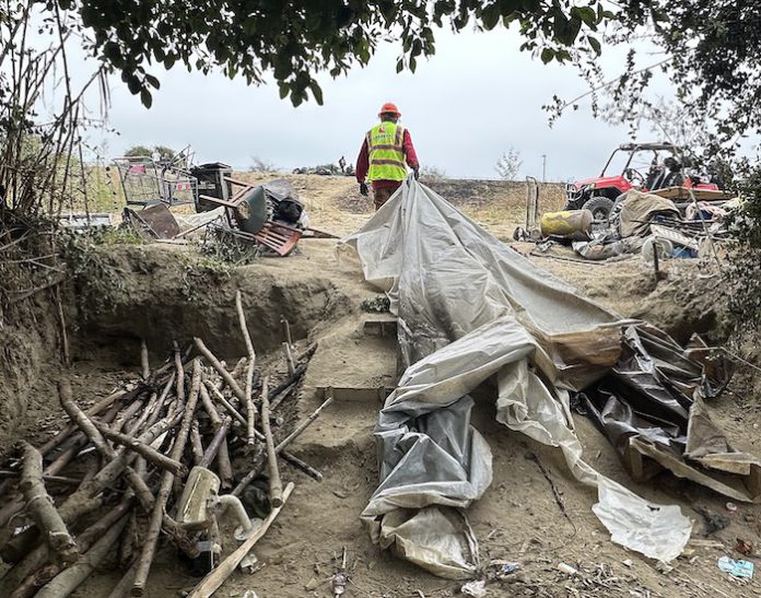 workers help clear makeshift shelters from the pajaro river levee