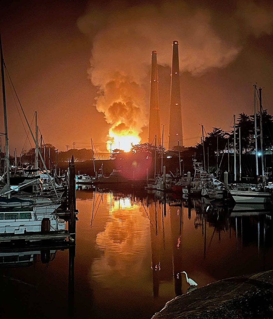 The fire at Moss Landing reflects off the waters of Moss Landing Harbor. (photo by Liza Azil)