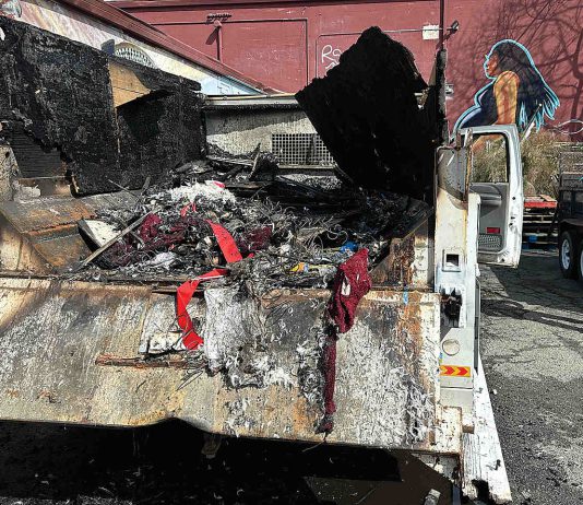 Chucky De Luna inspects the damage where a fire demolished a Ford F550 pickup at the rear loading area of Habitat for Humanity's Restore late Monday night on the 500 block of Main Street.