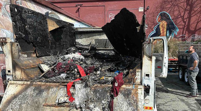 Chucky De Luna inspects the damage where a fire demolished a Ford F550 pickup at the rear loading area of Habitat for Humanity's Restore late Monday night on the 500 block of Main Street.