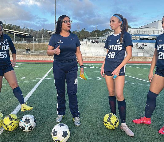 Gina Castañeda (second from left) works with the girls varsity soccer team at Aptos High School