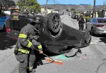 A Watsonville firefighter cleans up at the scene of a two-vehicle crash Tuesday afternoon on Center Street in Watsonville.