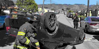 A Watsonville firefighter cleans up at the scene of a two-vehicle crash Tuesday afternoon on Center Street in Watsonville.