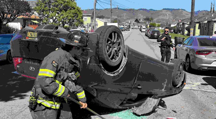 A Watsonville firefighter cleans up at the scene of a two-vehicle crash Tuesday afternoon on Center Street in Watsonville.
