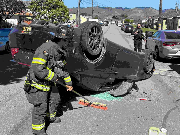 A Watsonville firefighter cleans up at the scene of a two-vehicle crash Tuesday afternoon on Center Street in Watsonville.