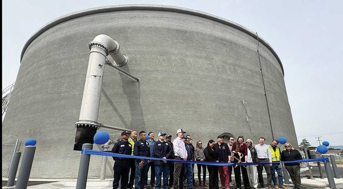 Watsonville Mayor Kristal Salcido (center with scissors) cuts the ribbon for the completion of a 2 million gallon water storage tank Monday on Burchell Avenue while joined by a cast of city officials.