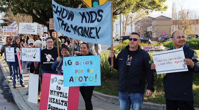 Pajaro Valley Unified School District teachers and staff are joined by community supporters early Tuesday morning at The Towers in Watsonville to rally against teacher layoffs.
