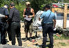 A “Notice To Vacate” flier is handed to Edward Lovell Thursday where he lives at a homeless encampment on Airport Boulevard.