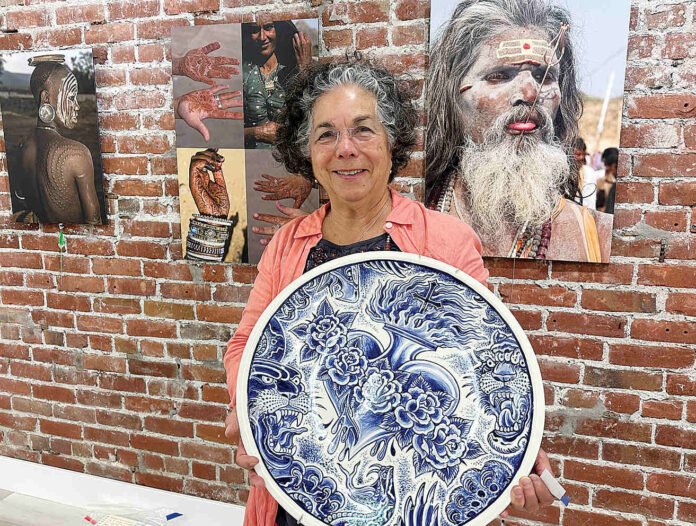 PV Arts 1 Roberta Valdez shows a ceramic work by Britton McFetridge. Valdez is the curator of the current exhibit at PV Arts in Watsonville. (Tarmo Hannula/The Pajaronian)
